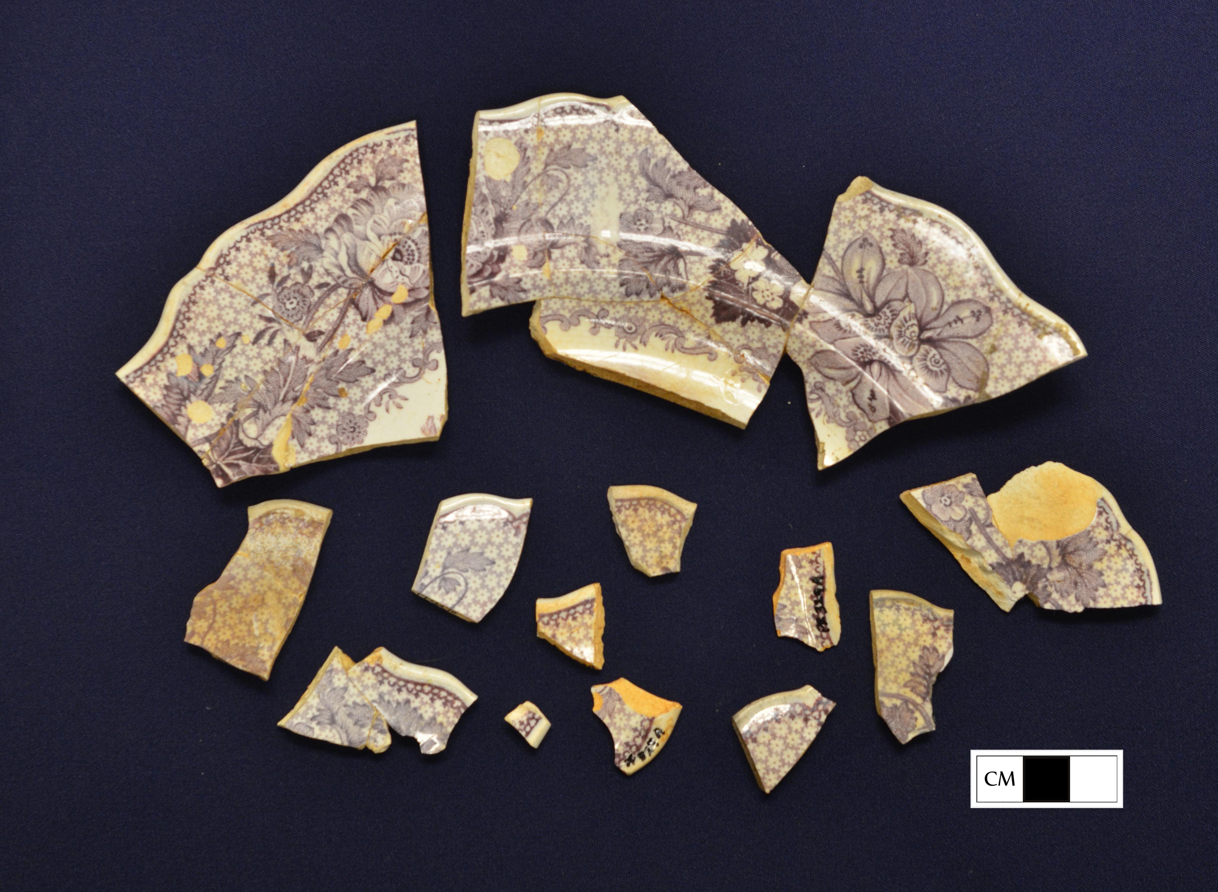 A mulberry transferprinted plate, with some slightly burned sherds.